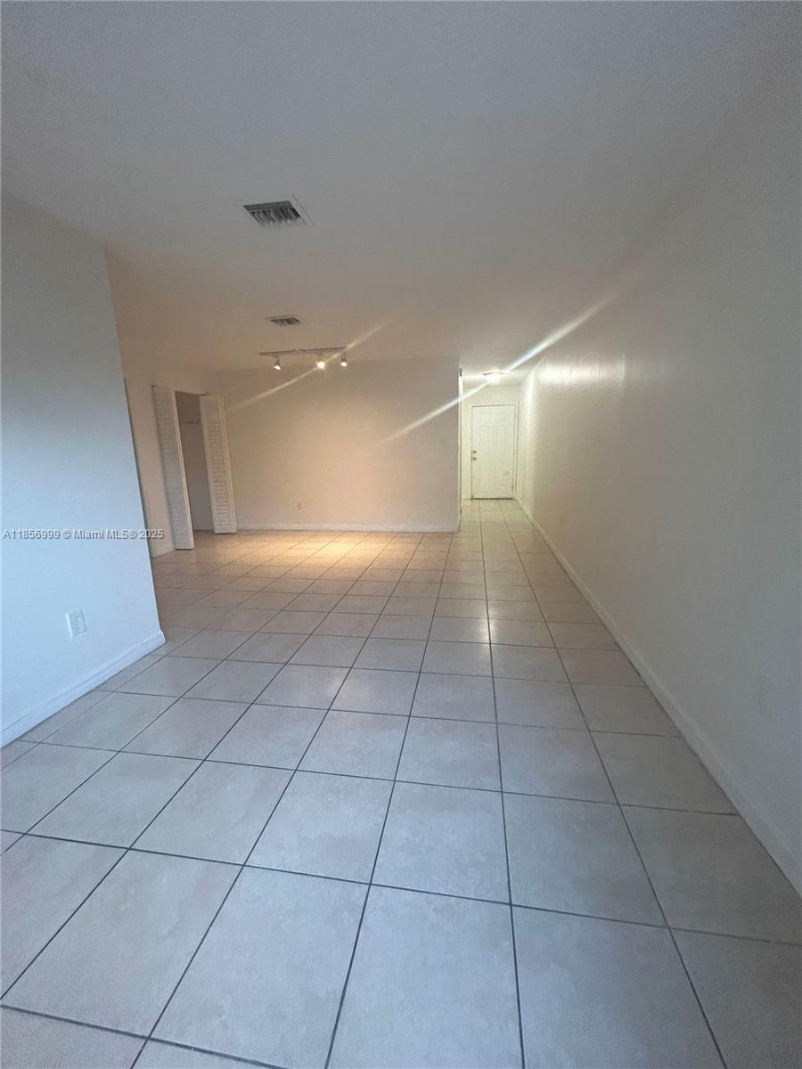 3876 Northwest 207 St Road, Unit 3876 Miami Gardens, FL 33055 - Photo 12 of 22 a view of a livingroom with an empty space and a chandelier fan