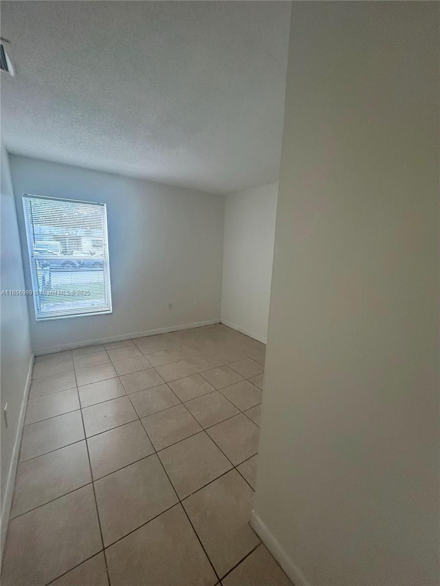 3876 Northwest 207 St Road, Unit 3876 Miami Gardens, FL 33055 - Photo 19 of 22 an empty room with a bench