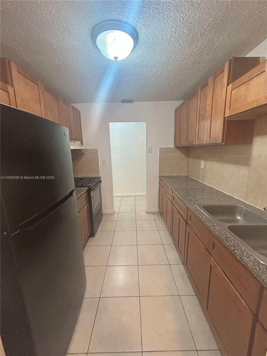 3876 Northwest 207 St Road, Unit 3876 Miami Gardens, FL 33055 - Photo 3 of 22 a kitchen with stainless steel appliances granite countertop a refrigerator and a sink
