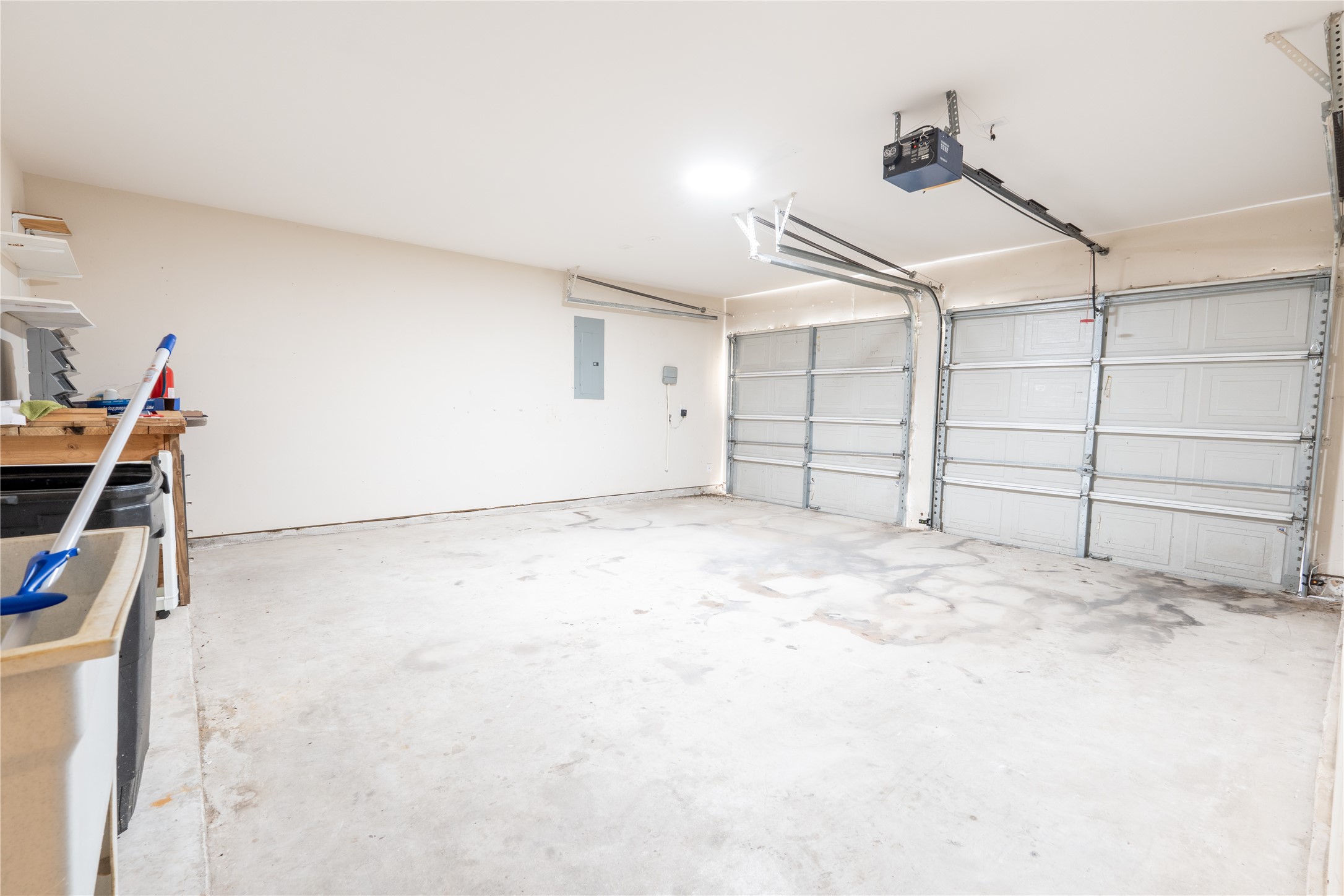 10619 Crownsedge Drive Spring, TX 77379 - Photo 27 of 38 This is a spacious two-car garage with clean walls and a concrete floor. It features overhead storage racks, a workbench, and an automatic garage door opener. Ideal for parking, storage, or a workshop.