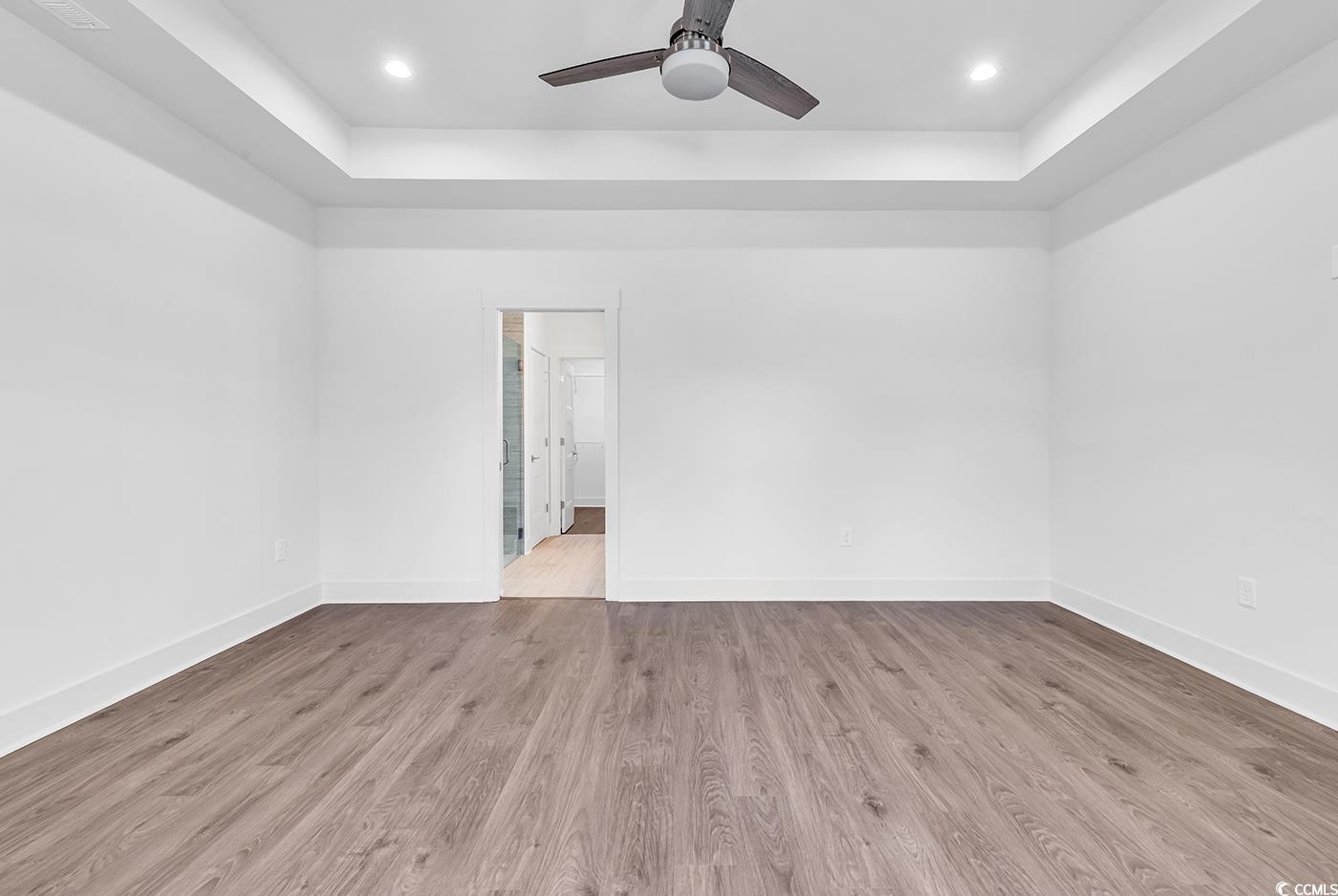 718 Highway 348 Loris, SC 29569 - Photo 18 of 28 Primary Bedroom featuring trey ceiling, recessed lighting, ceiling fan, wide baseboards and door trim, bay window seating area, and wood laminate flooring