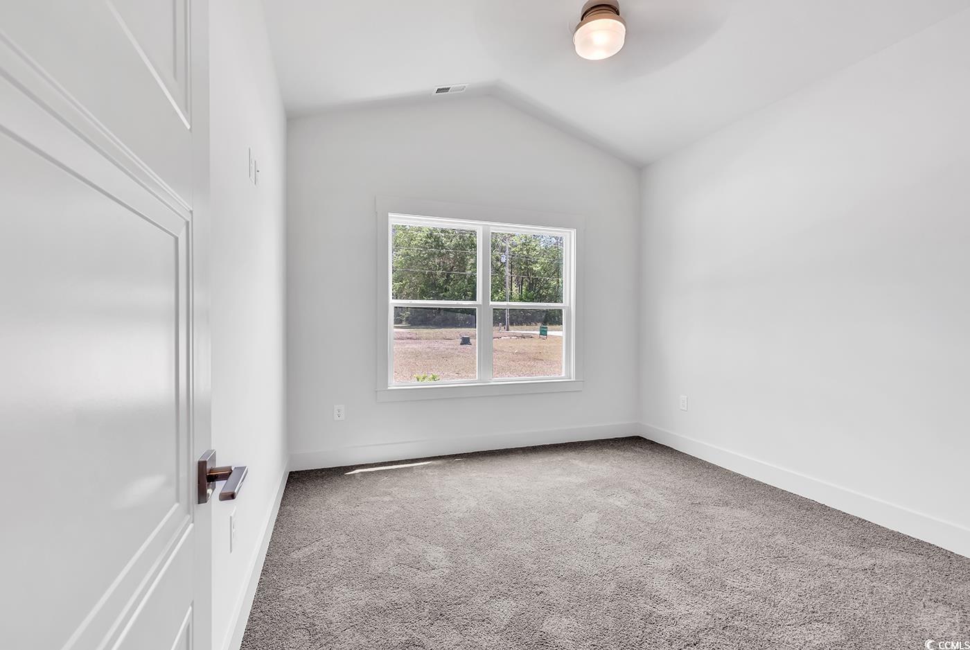 718 Highway 348 Loris, SC 29569 - Photo 23 of 28 Bedroom #1 with vaulted ceiling, carpet flooring, by-pass closet doors, wide baseboards and door trim, and a ceiling fan