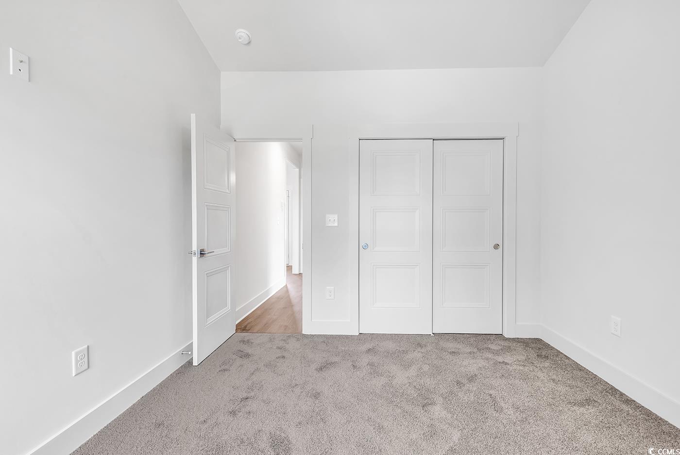718 Highway 348 Loris, SC 29569 - Photo 28 of 28 Bedroom #2 featuring carpet flooring, wide baseboards and door trim, and a closet with by-pass doors, ceiling fan