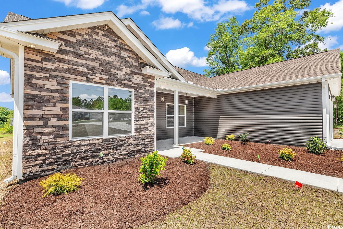 718 Highway 348 Loris, SC 29569 - Photo 3 of 28 View of front of home with a porch, a shingled roof, and stacked stone treatment