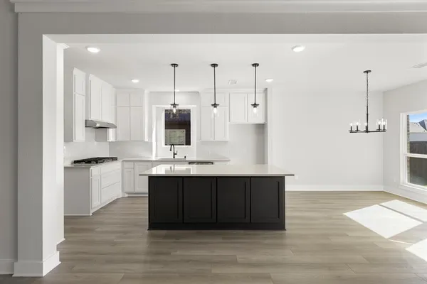 a large kitchen with cabinets wooden floor and stainless steel appliances