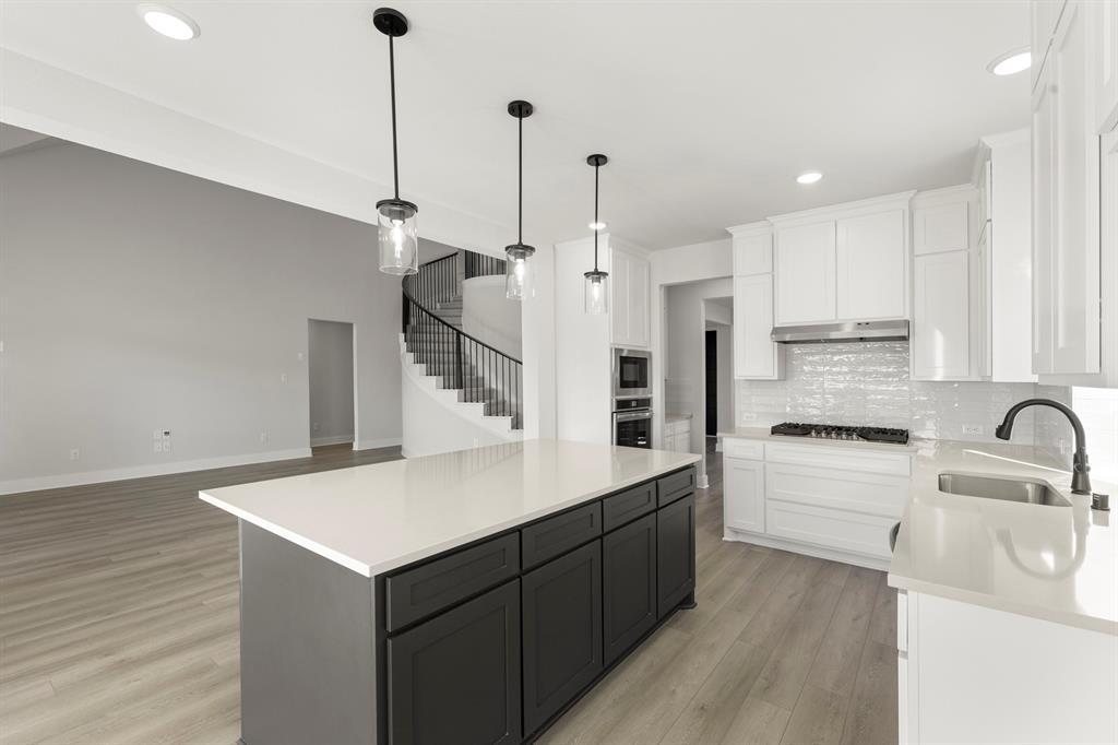 1285 Flamingo Road Forney, TX 75126 - Photo 22 of 40 a kitchen with kitchen island a sink stainless steel appliances and cabinets
