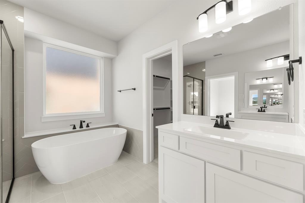1285 Flamingo Road Forney, TX 75126 - Photo 30 of 40 a bathroom with a double vanity sink mirror and bathtub