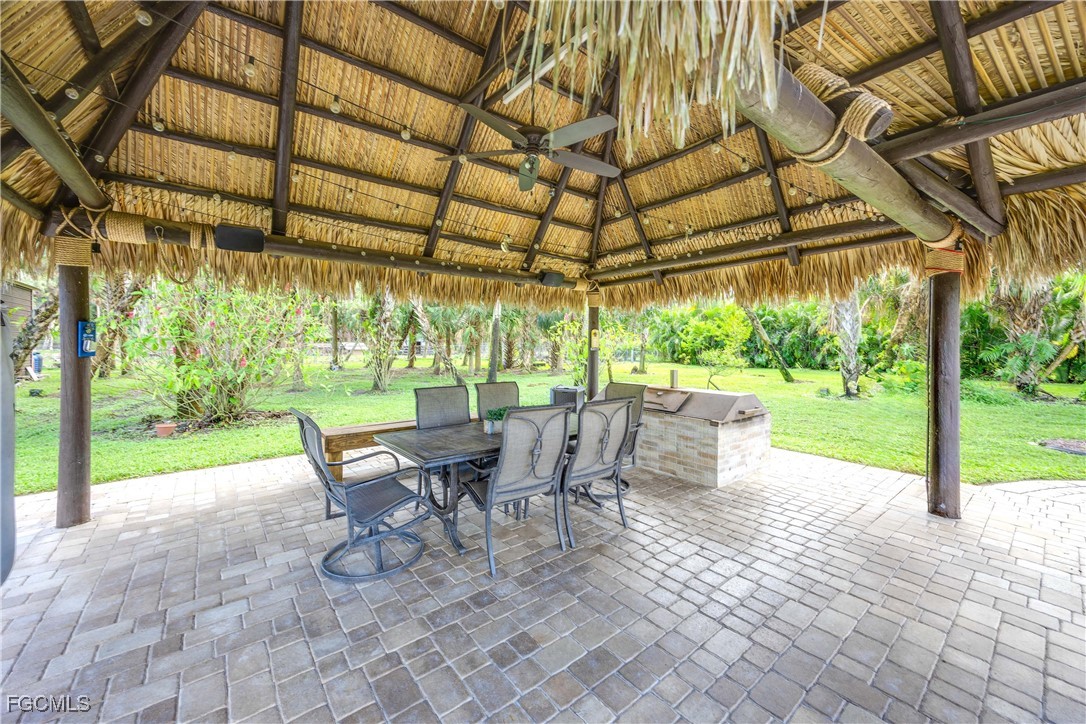 214 9th Street Northwest Naples, FL 34120 - Photo 42 of 49 a view of a patio with a table chairs and a backyard