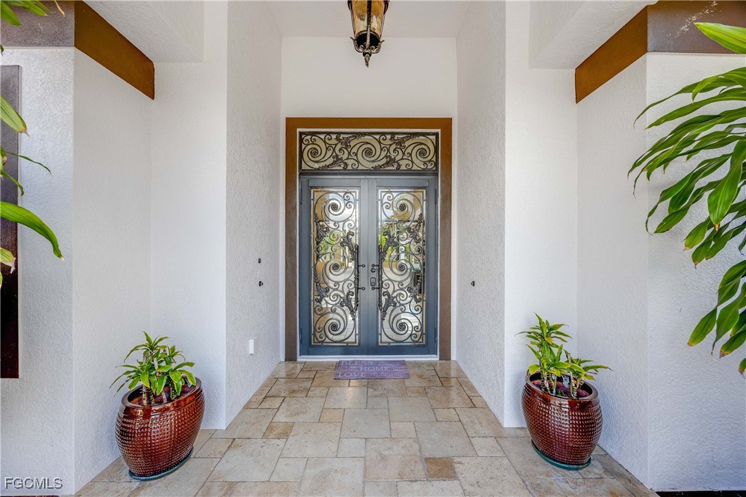 214 9th Street Northwest Naples, FL 34120 - Photo 47 of 49 a view of front door with potted plant