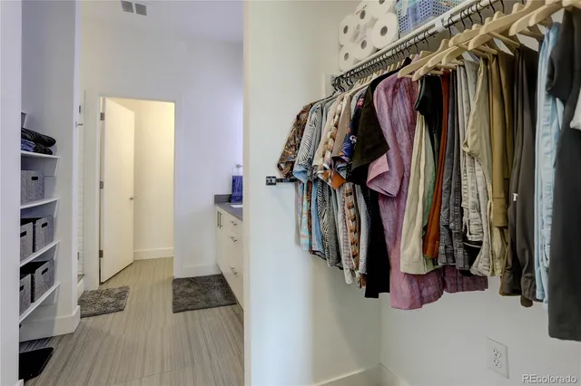 a view of walk in closet with clothes and shoes
