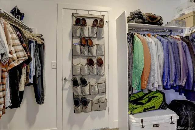 a view of walk in closet with clothes and shoes