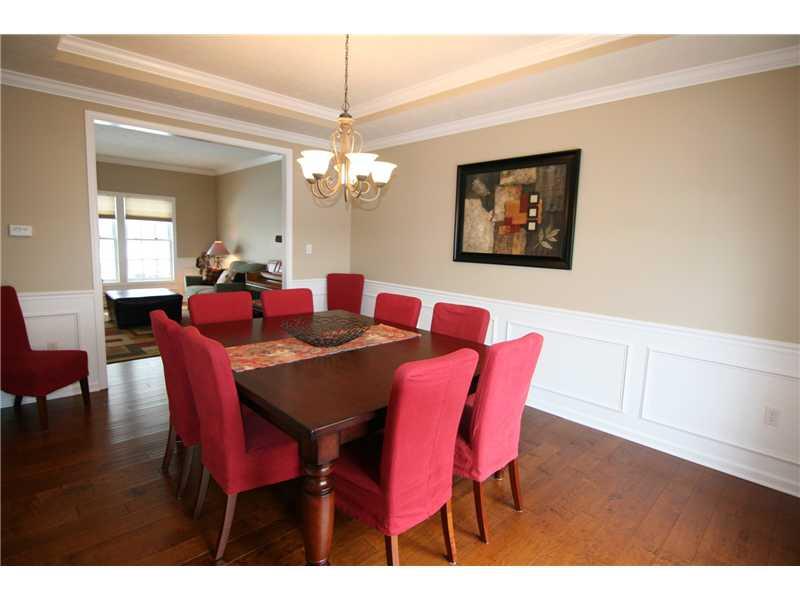 Dining Room. Continued hardwood flooring, crown molding, chair rail, wainscoting...Notice the tray ceiling...