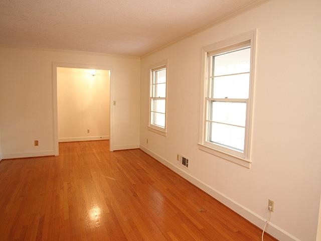 6700 Johnsdale Road Raleigh, NC 27615 - Photo 2 of 14 an empty room with wooden floor and windows