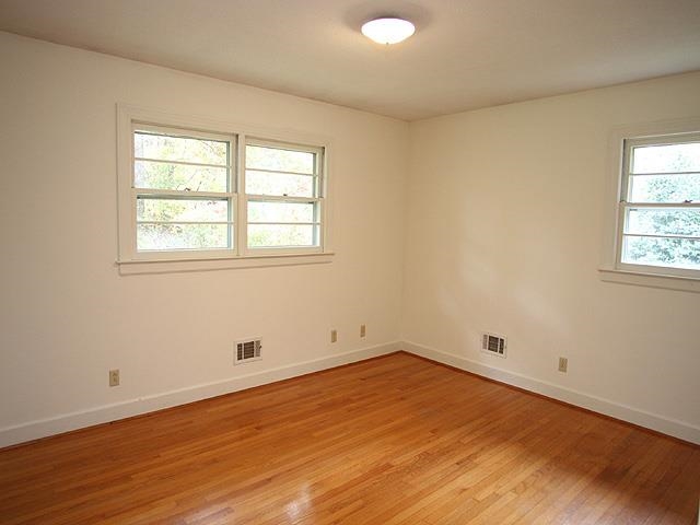 6700 Johnsdale Road Raleigh, NC 27615 - Photo 7 of 14 an empty room with wooden floor and windows