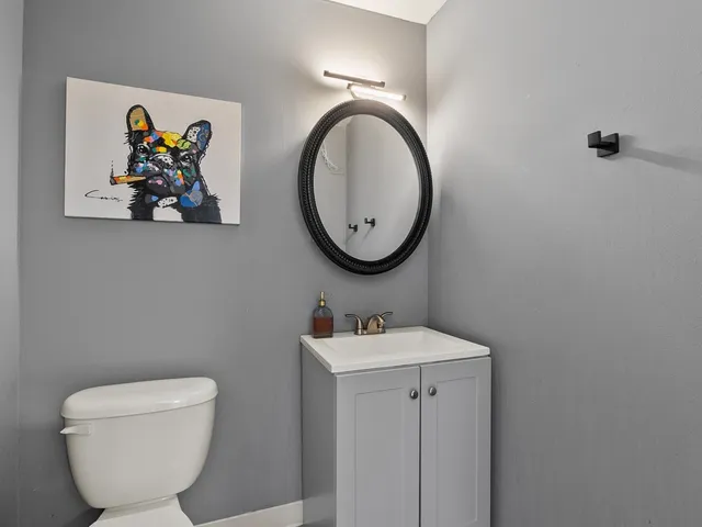 a bathroom with a toilet a sink and mirror
