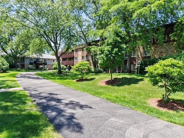a view of a house with a big yard and large trees