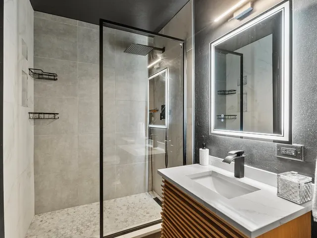 a bathroom with a sink shower and a mirror