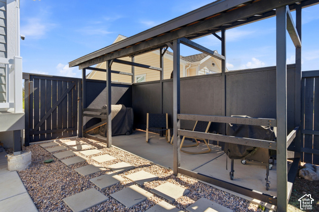986 South Old Farm Road Heber City, UT 84032 - Photo 51 of 51 Outdoor patio area featuring a pergola, privacy fencing, a concrete pad, and a gravel path with stepping stones