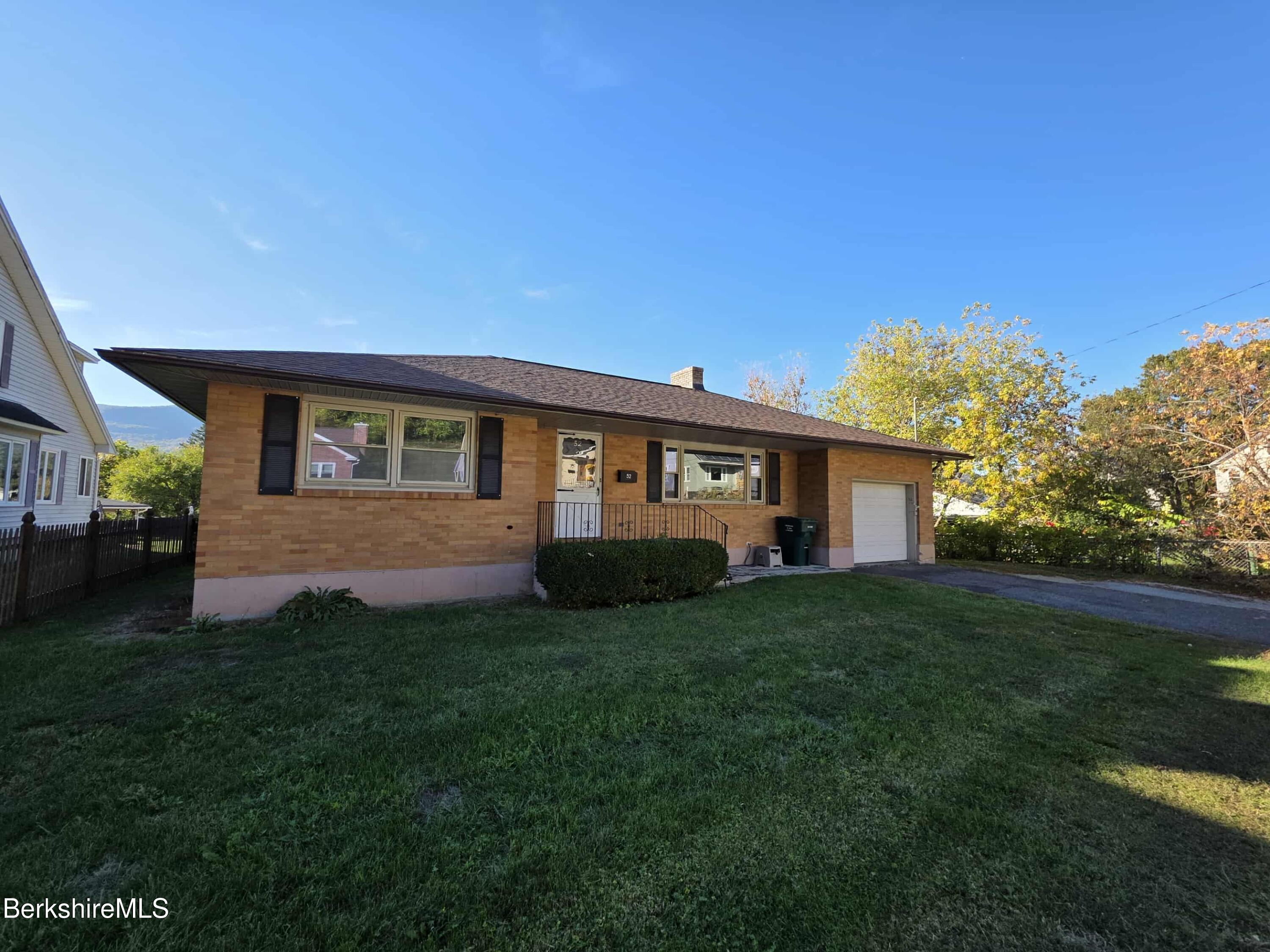 a view of a yard in front of a house with large trees