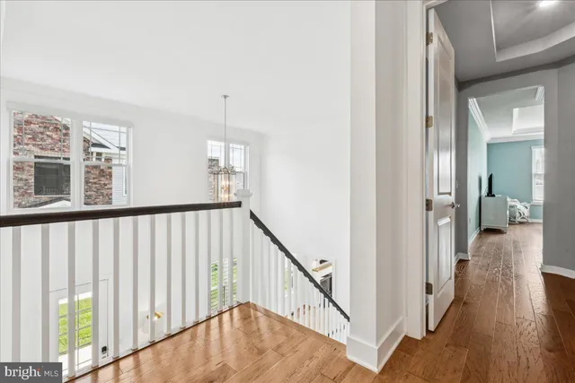 a view of hallway with wooden floor and stairs