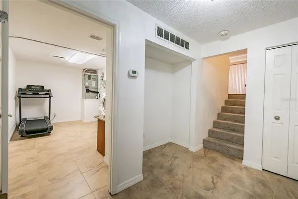 a view of a hallway to an empty room and stairs
