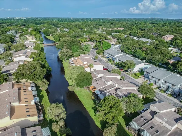 an aerial view of residential houses with outdoor space and trees