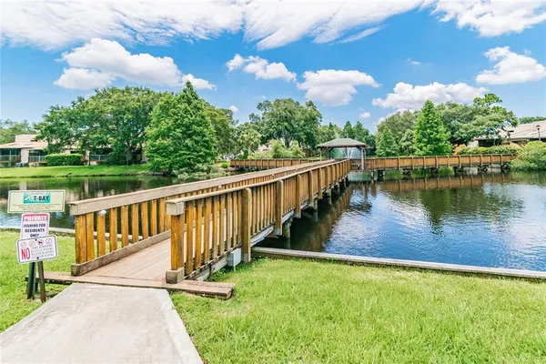 a view of a lake with a floor to ceiling window next to a yard