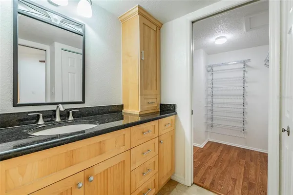 a bathroom with a granite countertop sink and a mirror