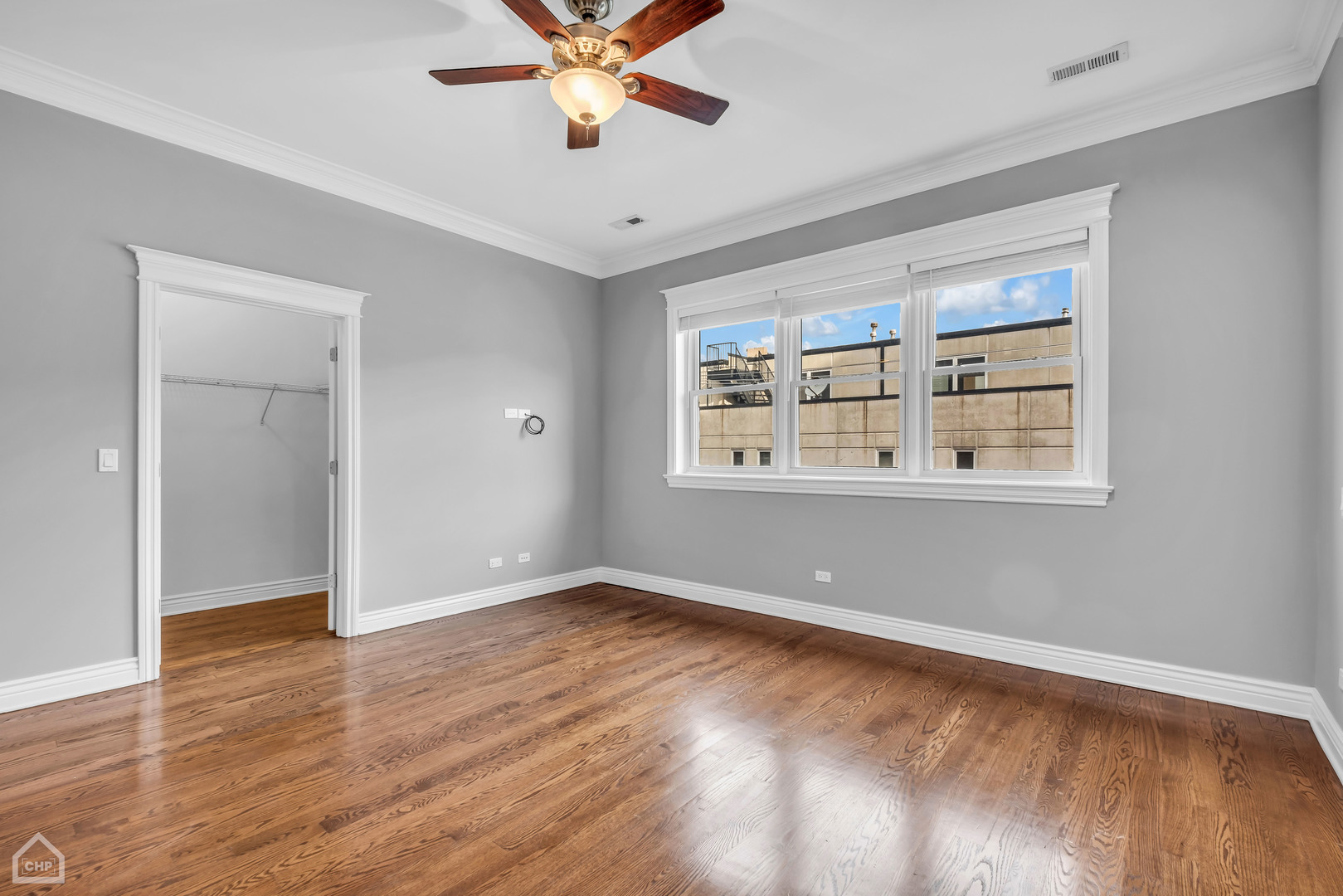 1248 West Jackson Boulevard, Unit 3E Chicago, IL 60607 - Photo 11 of 20 a view of an empty room with wooden floor and a window