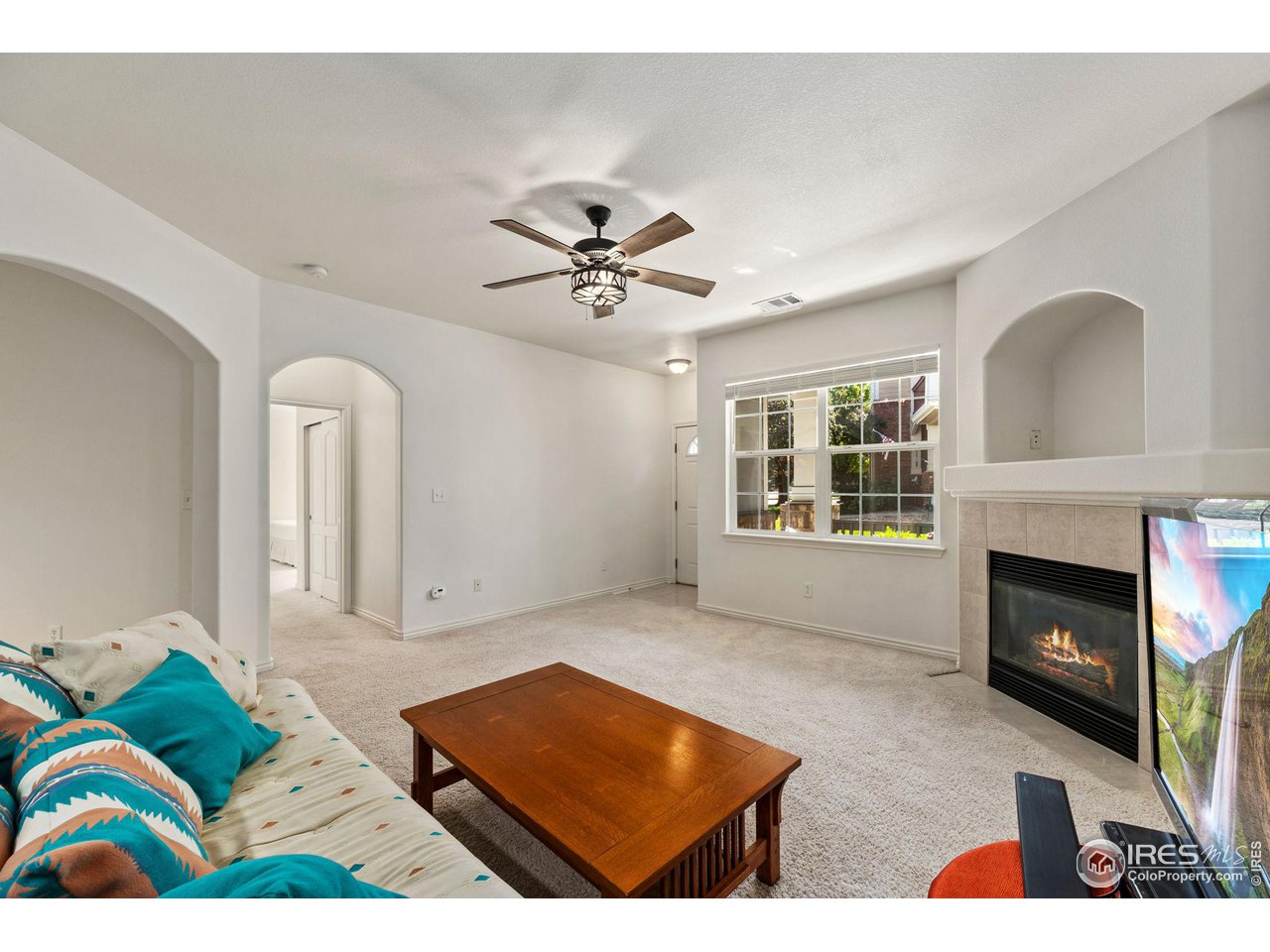 4672 West 20th Road, Unit 2212 Greeley, CO 80634 - Photo 12 of 40 Arched entries create an expansive feeling in the living room and a gas fireplace ensures a welcoming atmosphere.