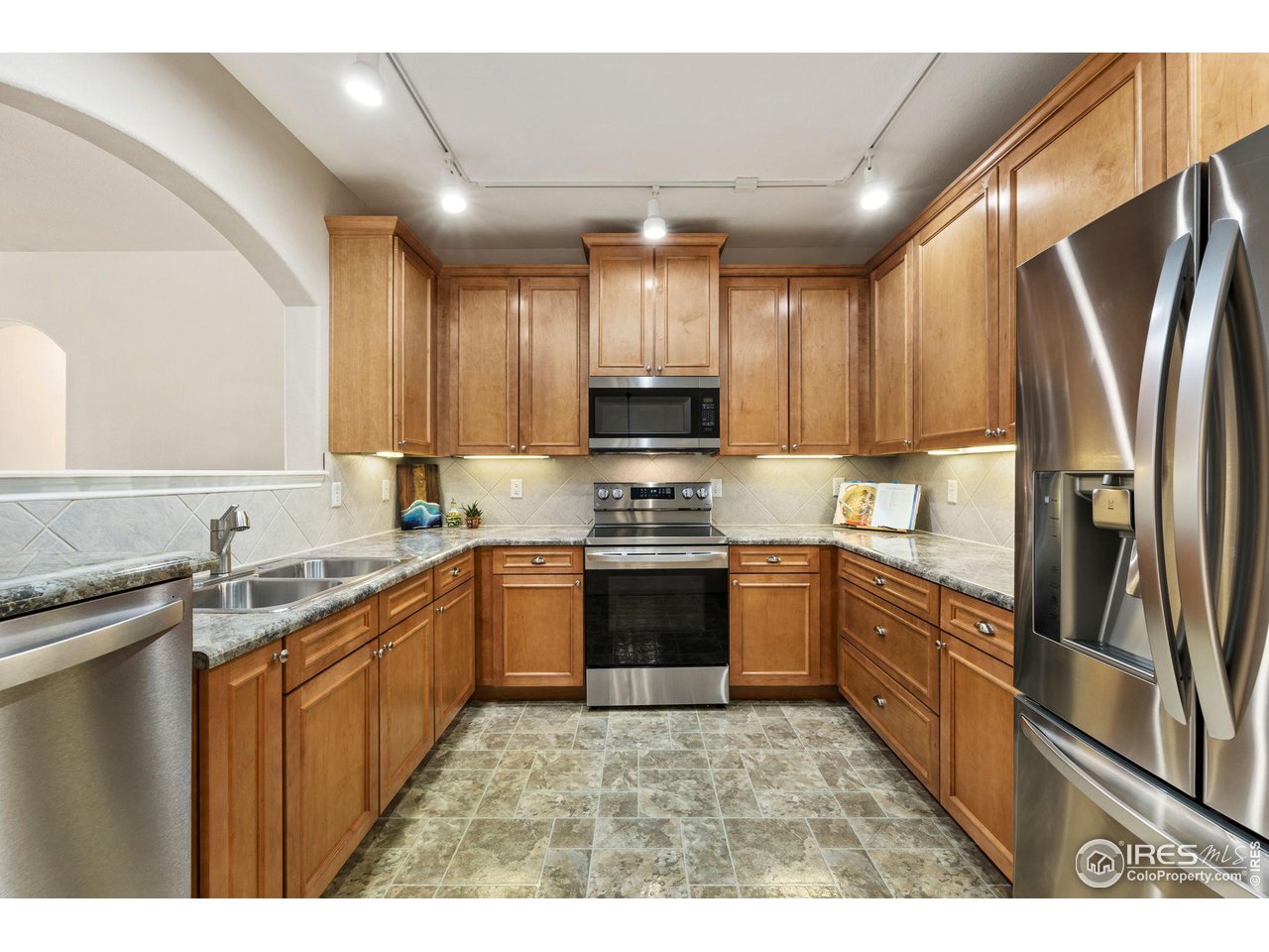 4672 West 20th Road, Unit 2212 Greeley, CO 80634 - Photo 16 of 40 Crown molding accents the natural maple wood grain of the abundant cabinets and the stainless steel of the appliances gives the kitchen a modern feel.