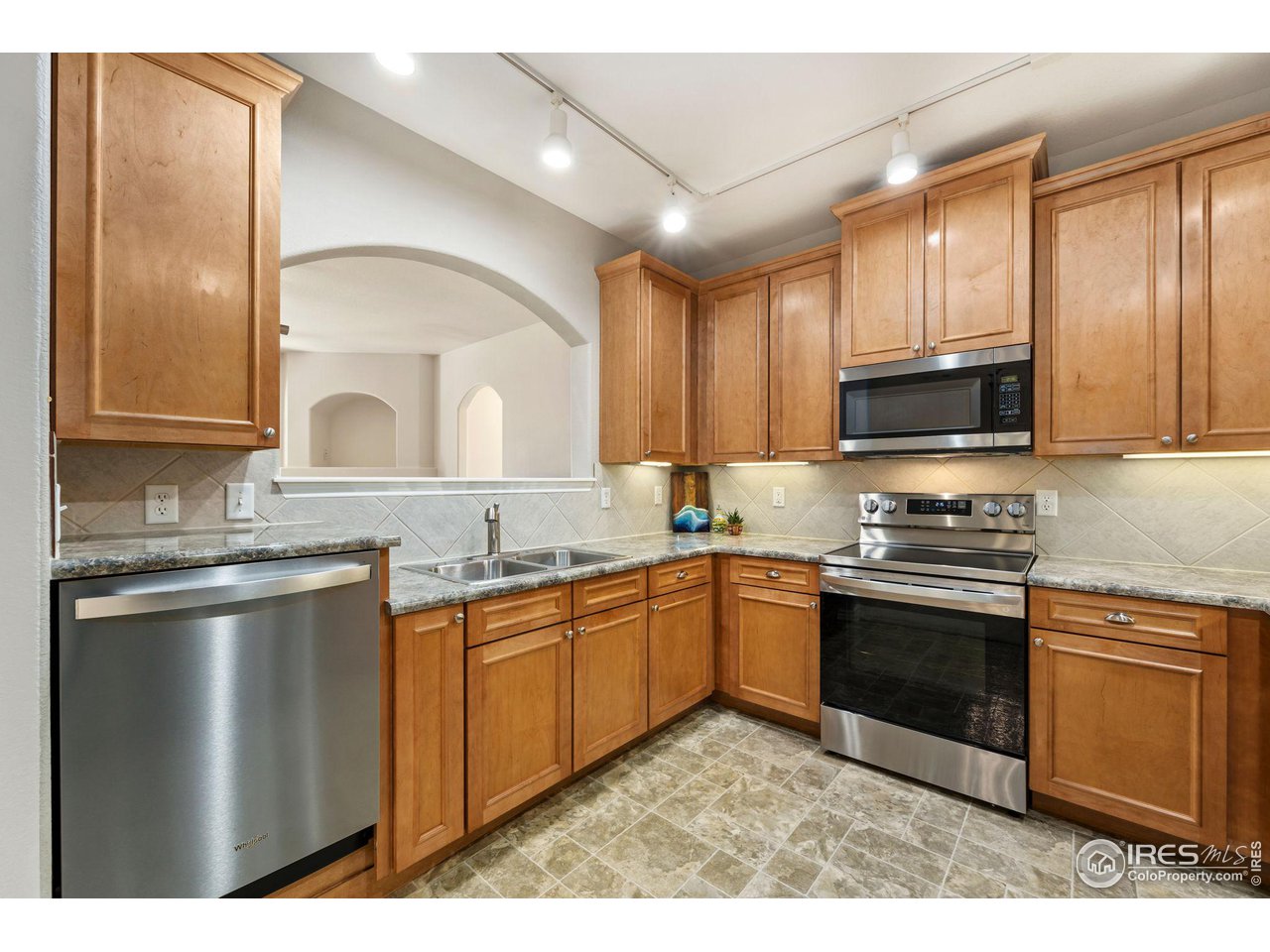 4672 West 20th Road, Unit 2212 Greeley, CO 80634 - Photo 17 of 40 Crown molding accents the natural maple wood grain of the abundant cabinets and the stainless steel of the appliances gives the kitchen a modern feel.