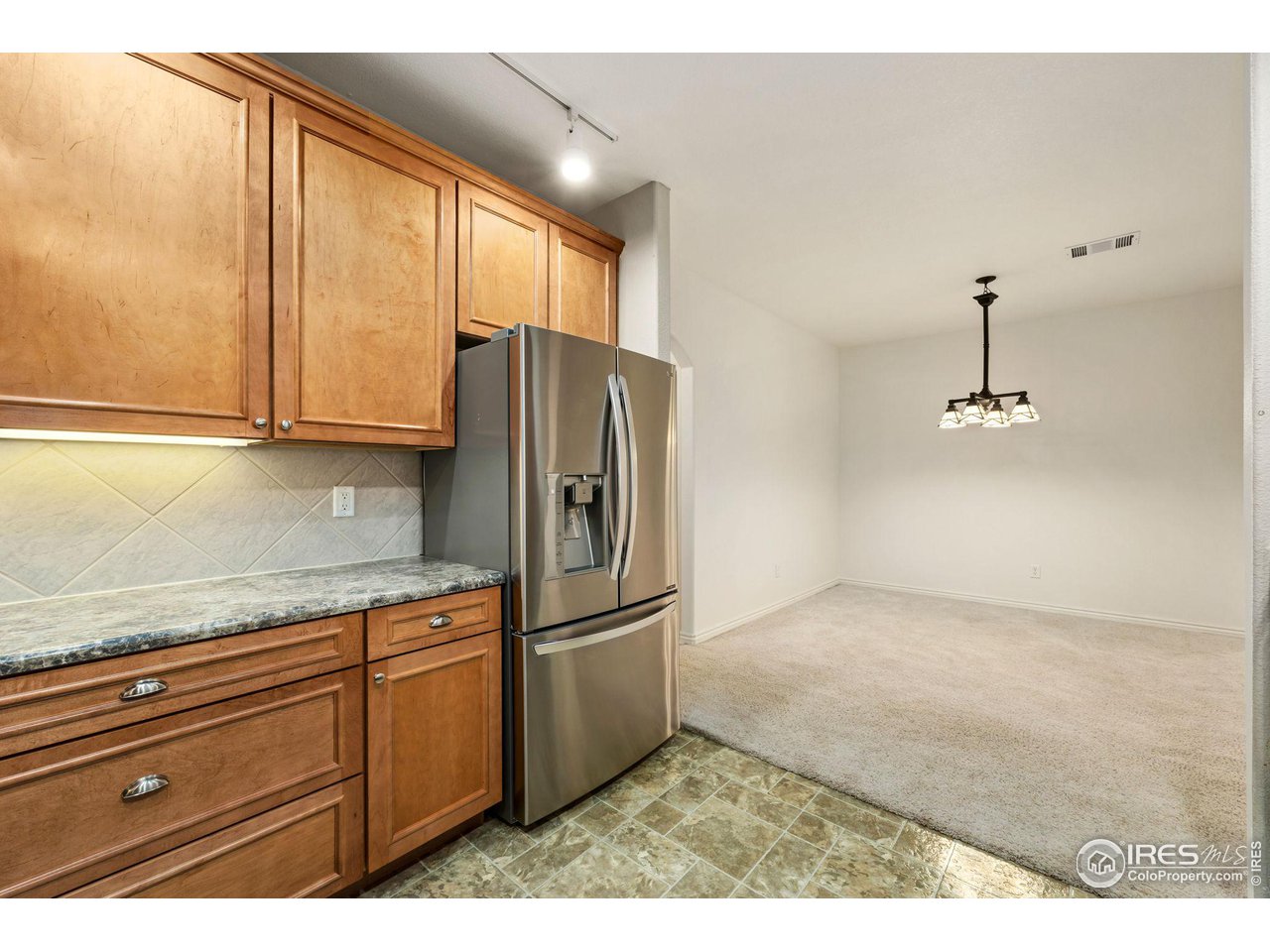 4672 West 20th Road, Unit 2212 Greeley, CO 80634 - Photo 20 of 40 Crown molding accents the natural maple wood grain of the abundant cabinets and the stainless steel of the appliances gives the kitchen a modern feel.