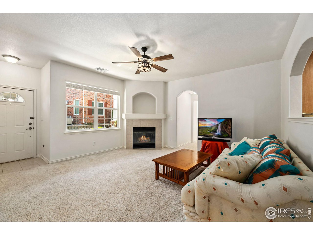 4672 West 20th Road, Unit 2212 Greeley, CO 80634 - Photo 4 of 40 Arched entries create an expansive feeling in the living room and a gas fireplace ensures a welcoming atmosphere.