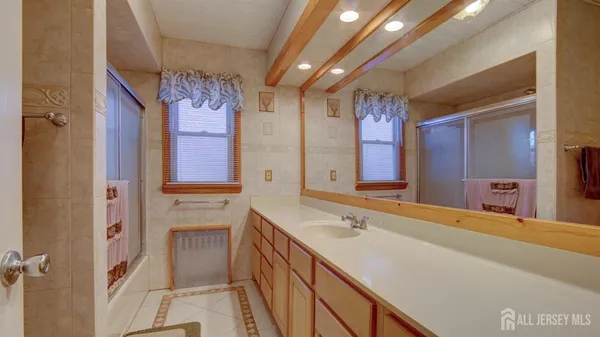 a spacious bathroom with a sink shower and a mirror