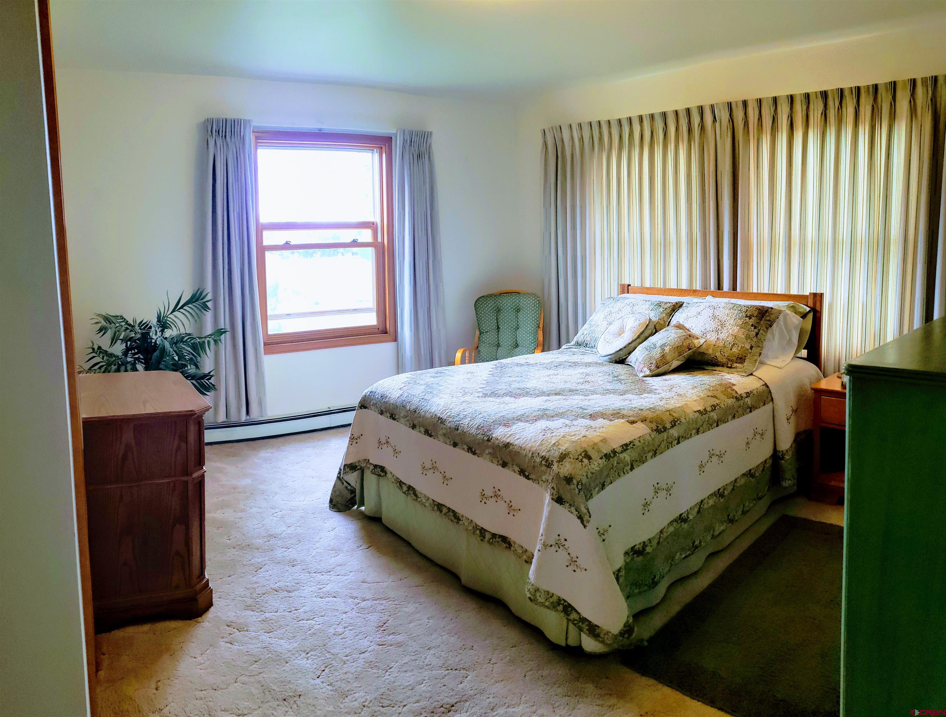 21669 Myers Road Orchard City, CO 81418 - Photo 17 of 35 a bed sitting in a spacious bedroom next to a window