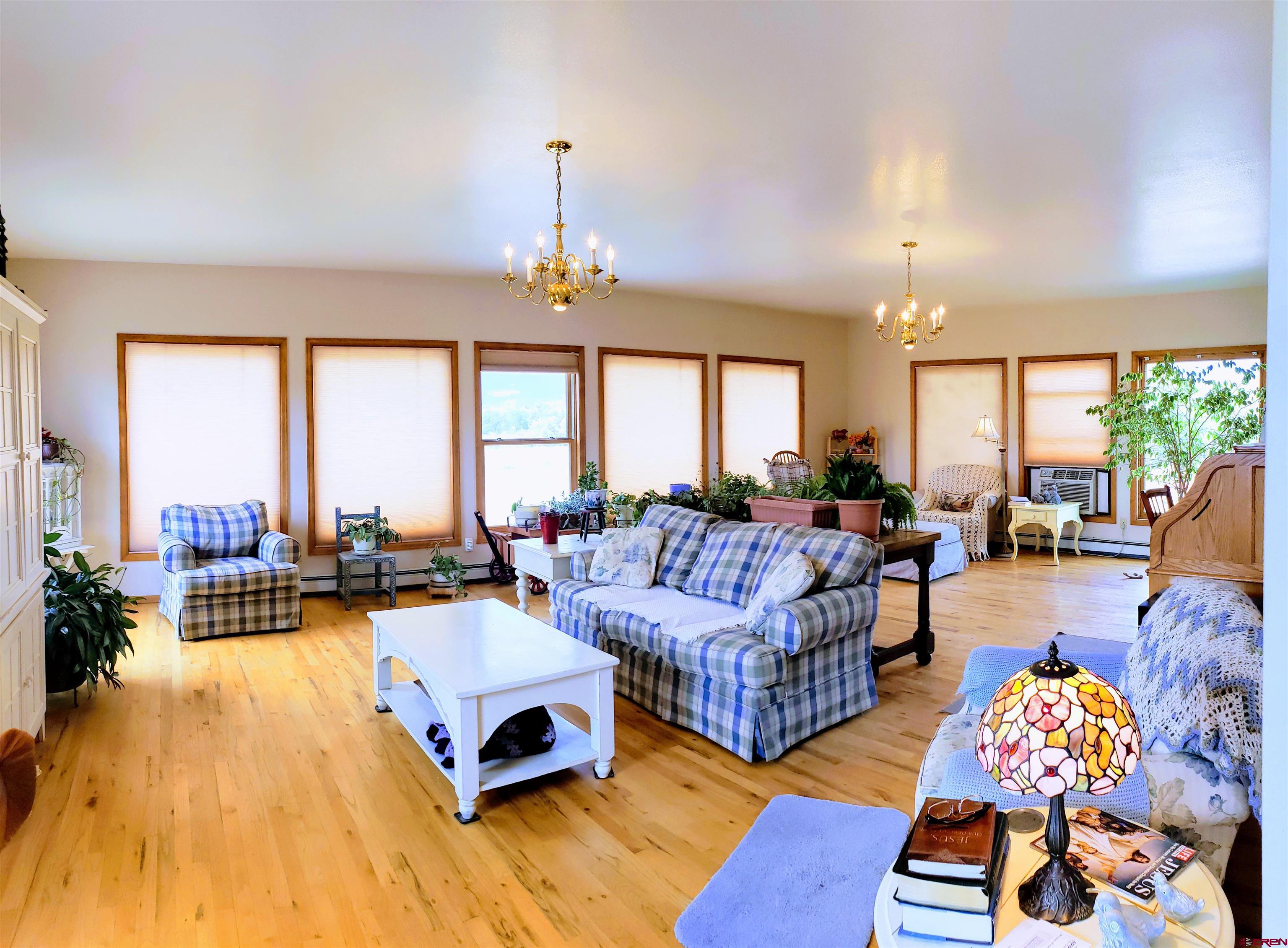 21669 Myers Road Orchard City, CO 81418 - Photo 8 of 35 a living room with furniture fireplace and a large window