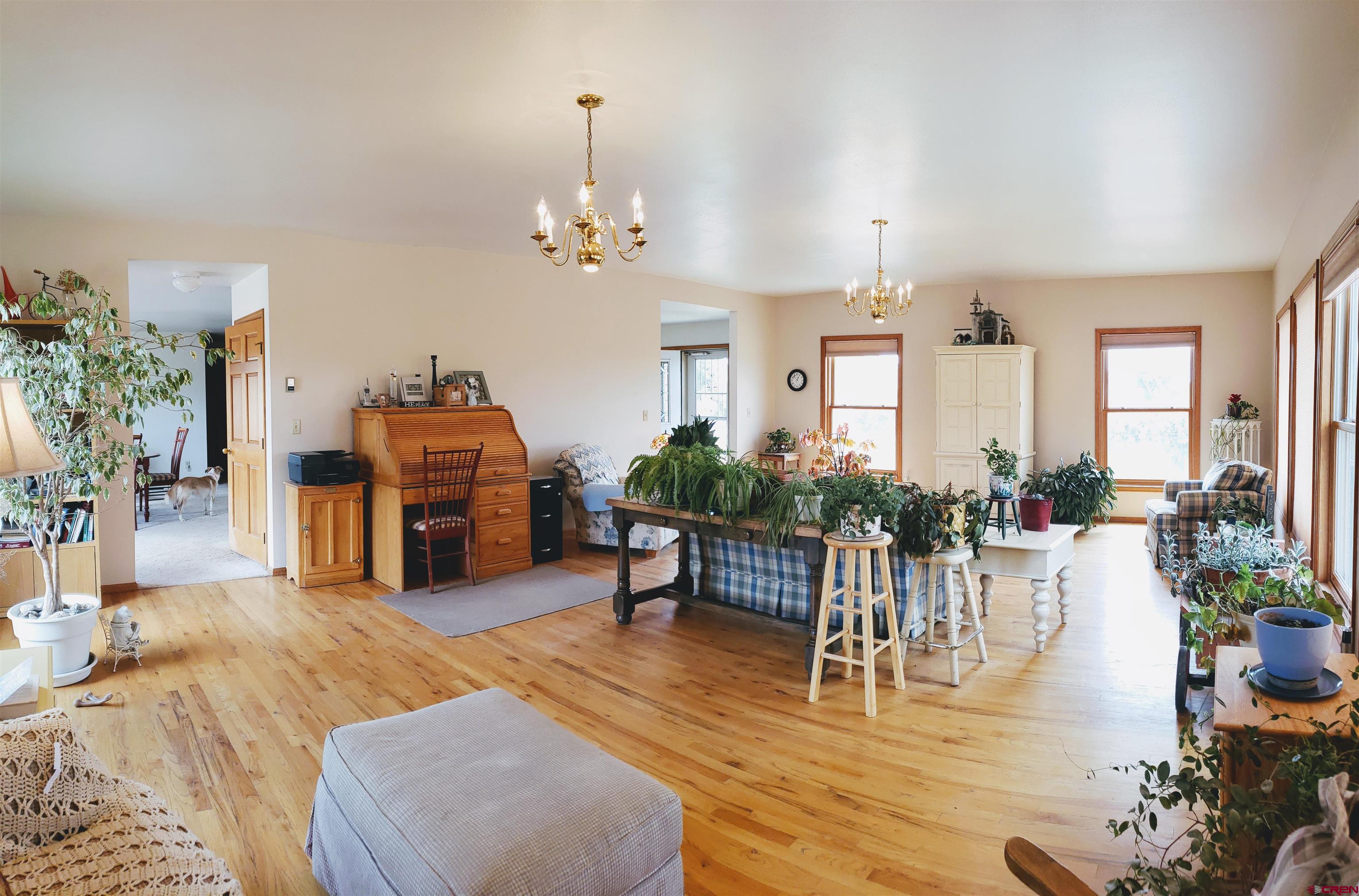 21669 Myers Road Orchard City, CO 81418 - Photo 10 of 35 a living room with furniture a chandelier and a dining room