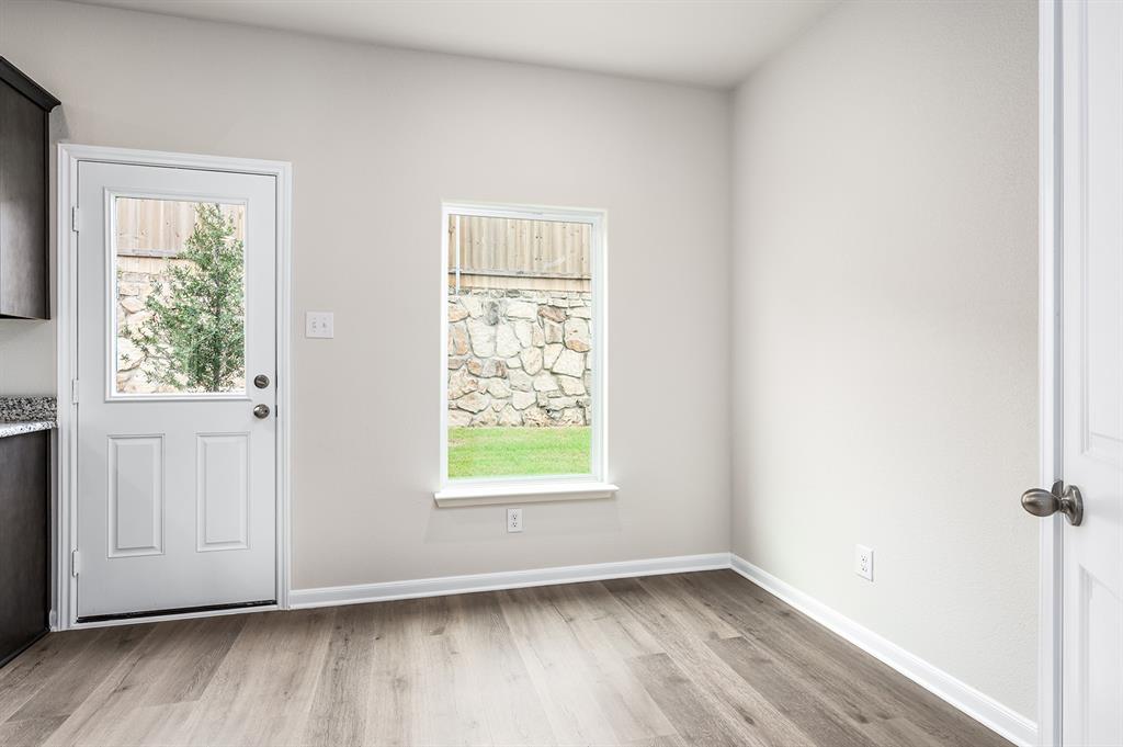6326 Emerald Tree Lane Dallas, TX 75241 - Photo 10 of 20 an empty room with wooden floor and windows