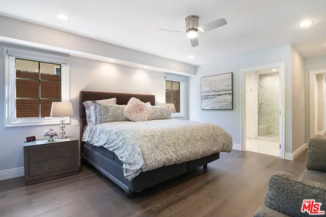 a spacious bedroom with a bed and a chandelier