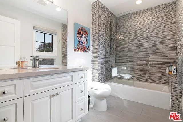 a bathroom with a granite countertop toilet sink and mirror