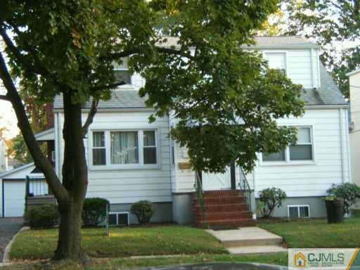 649 Front Street Dunellen, NJ 08812 - Photo 2 of 2 a front view of a house with a yard and a garage