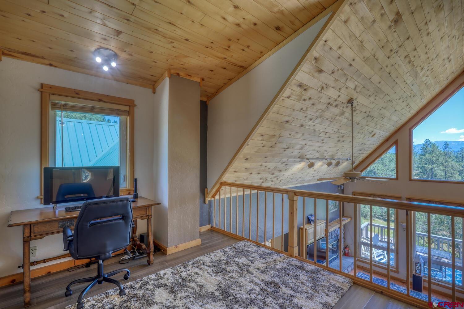 569 Eight Mile Loop Pagosa Springs, CO 81147 - Photo 13 of 31 a view of workspace with wooden floor windows