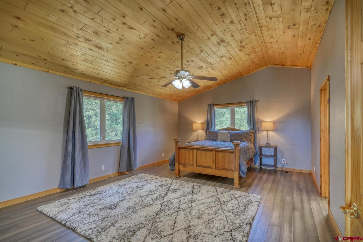 569 Eight Mile Loop Pagosa Springs, CO 81147 - Photo 15 of 31 a bedroom with a bed and wooden floor