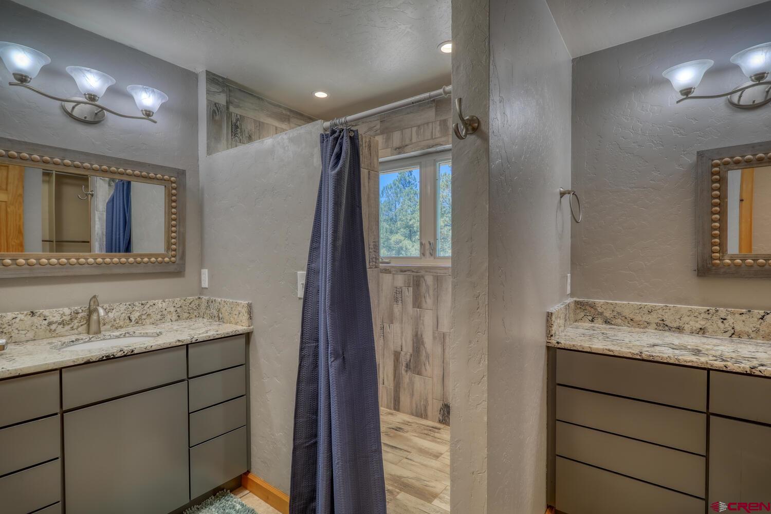 569 Eight Mile Loop Pagosa Springs, CO 81147 - Photo 18 of 31 a bathroom with a granite countertop sink mirror and double