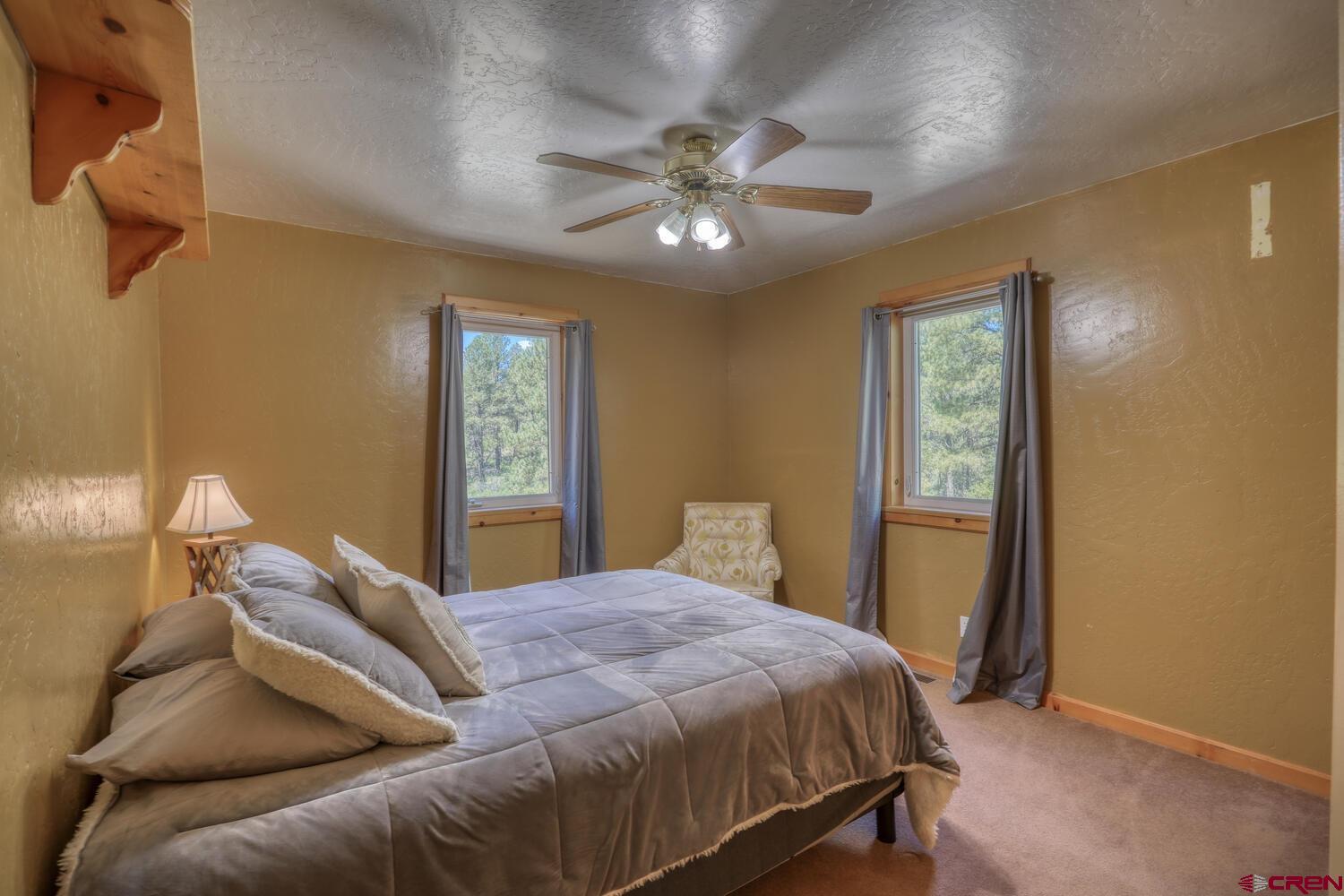 569 Eight Mile Loop Pagosa Springs, CO 81147 - Photo 23 of 31 a bedroom with a bed and a window
