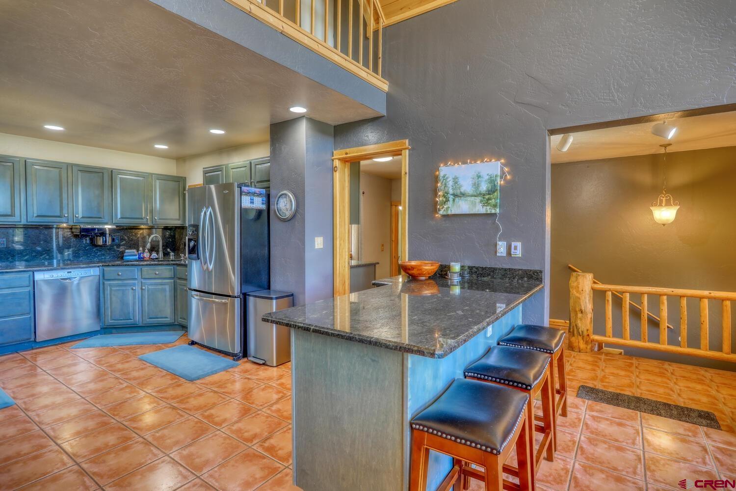 569 Eight Mile Loop Pagosa Springs, CO 81147 - Photo 9 of 31 a kitchen with stainless steel appliances granite countertop a refrigerator and a sink