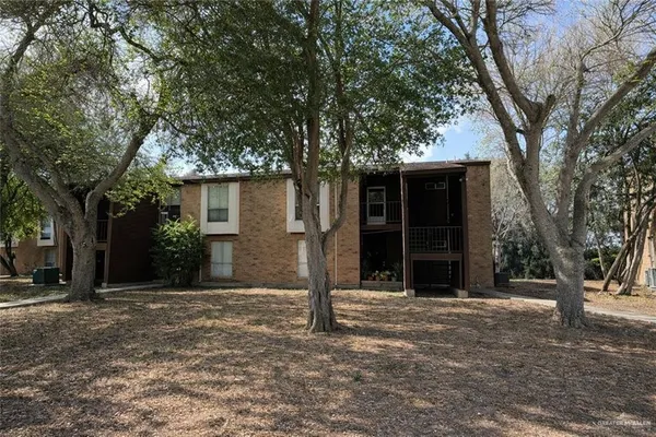 a front view of a house with a tree