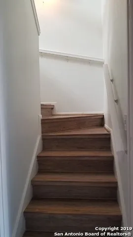 a view of staircase with wooden floor and potted plant