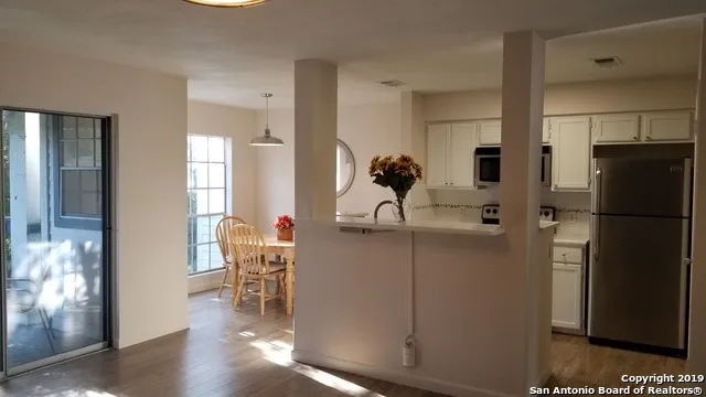 a kitchen with stainless steel appliances a refrigerator and a wooden floor